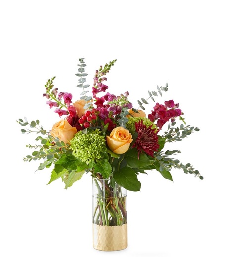 fall-toned floral arrangement with golden toned roses and deep burgundy flowers