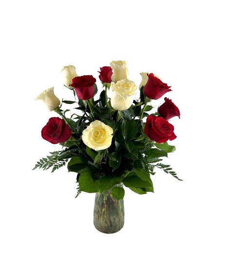 Six red roses and six white roses with greenery in a frosted green vase