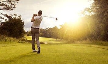 man on golf course in afternoon amber light